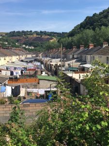 Bild einer Reihe von Reihenhäusern und Gärten in einem ländlichen Tal.